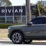 A Rivian electric pickup truck in a parking lot of a Rivian service center