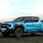 A bright blue Nikola pick-up truck parked on a rural road with a grassy landscape in the background